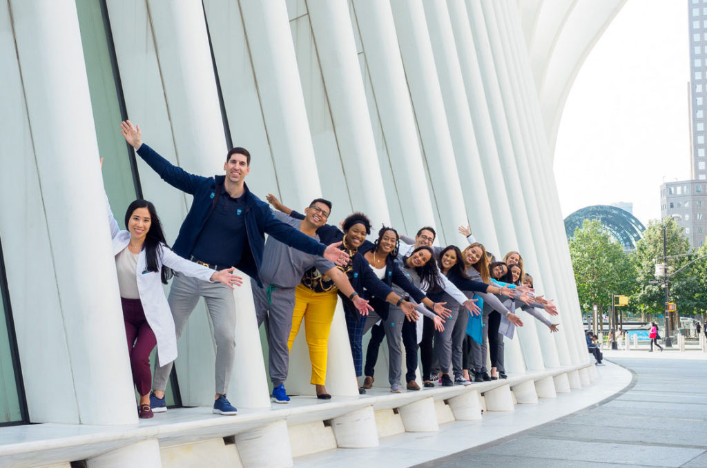 Sky Dental team poses on the base of the Oculus, leaning out, arms outstretched, as if performing a musical.