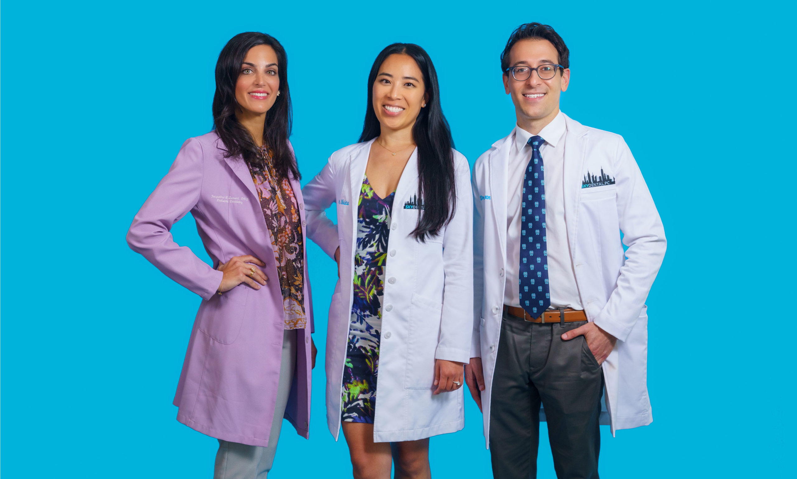 Sky Dental Dentists against a sky-blue background. Left to right: Dr. Jacqueline Zamani, Dr. Wonnie Rhieu, and Dr. Ross Newman